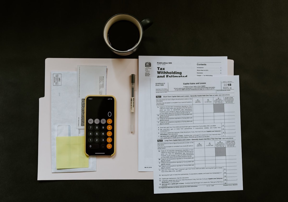 Telemóvel e caneta sobre documentos de contas