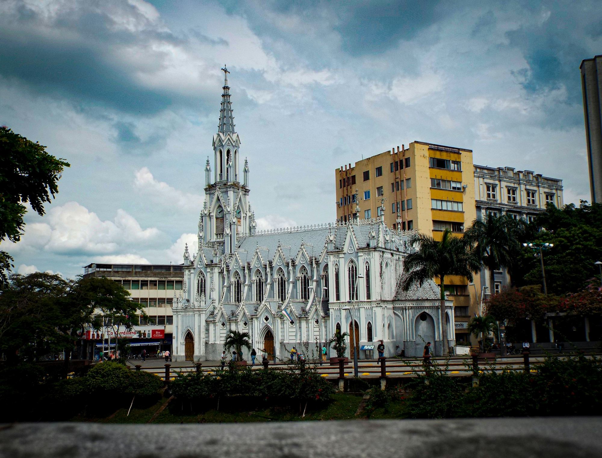 Iglesia neogótica en el centro de Cali, con palmas y la avenida al frente