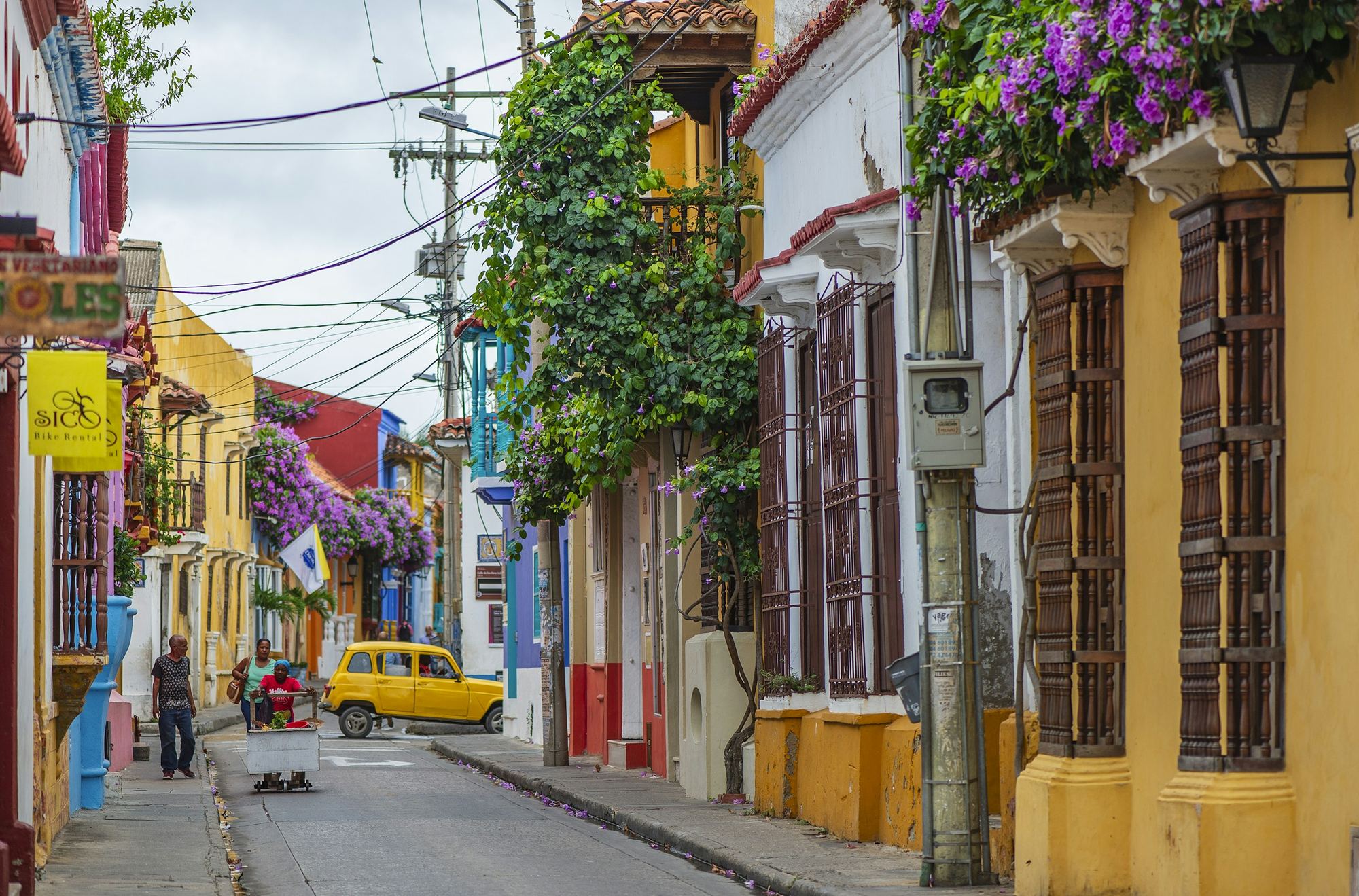 Calle del centro histórico de Cartagena, con fachadas de colores y un carro amarillo
