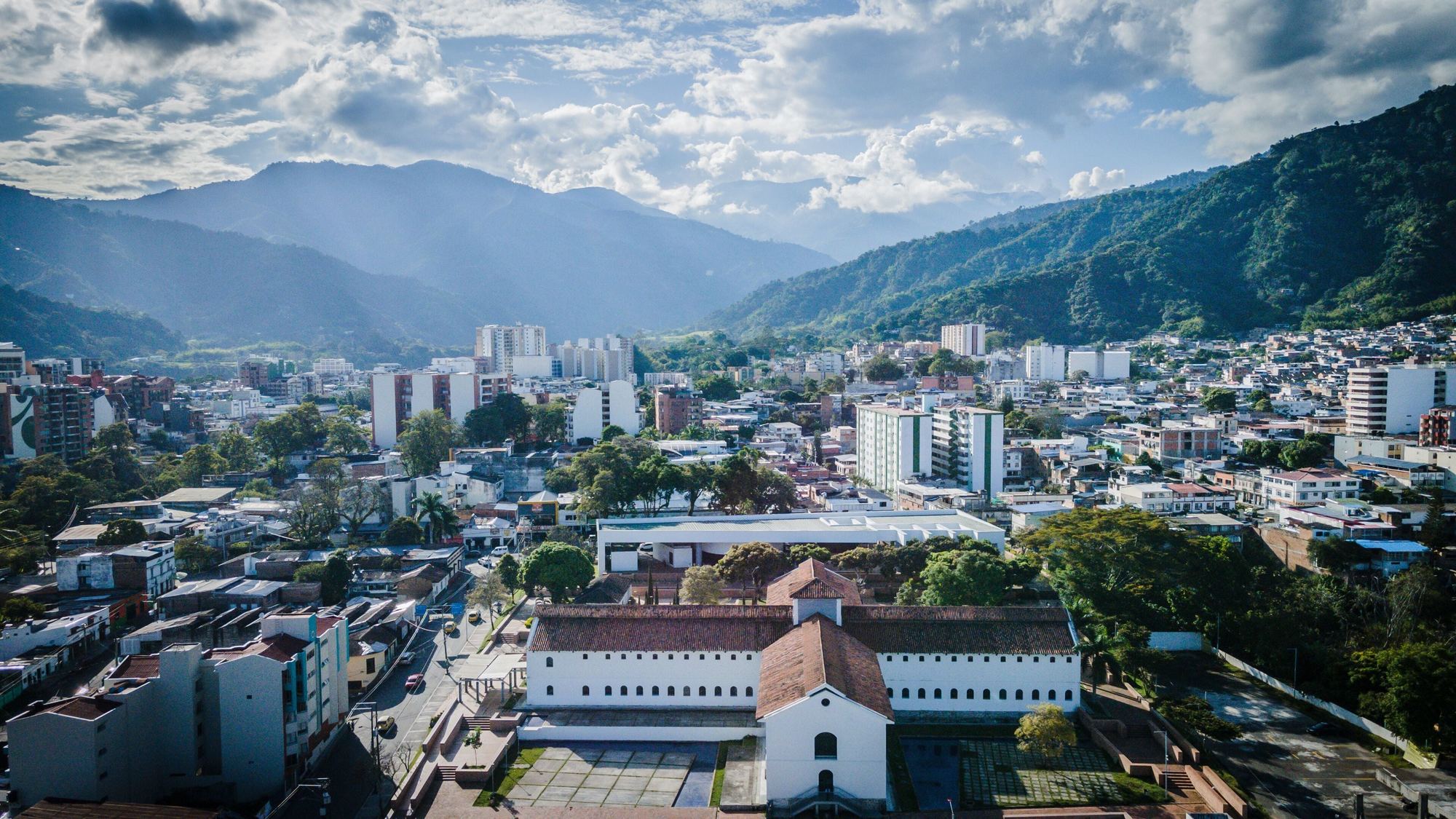 Ibagué desde el aire, con un edificio colonial en primer plano y la cordillera al fondo