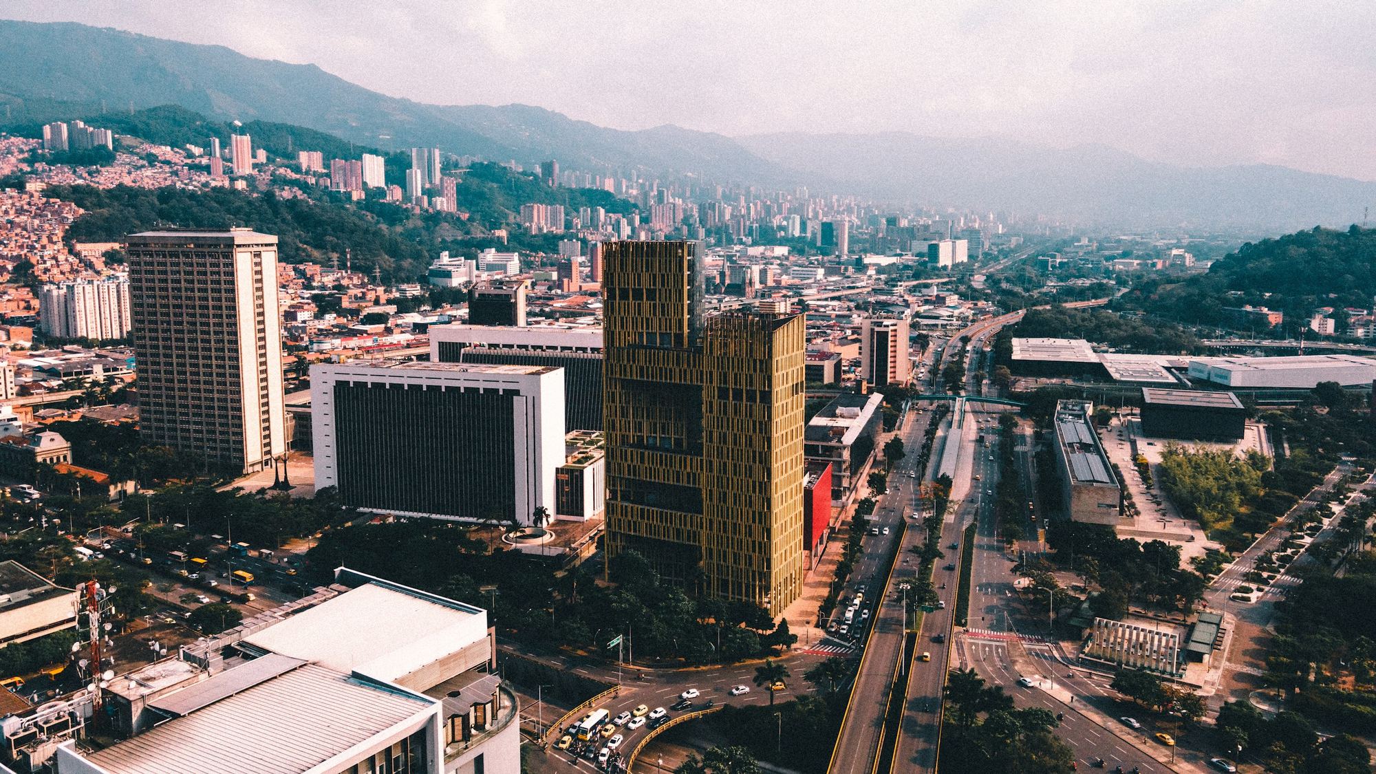 La avenida principal de Medellín desde el aire, con las torres y las montañas al fondo