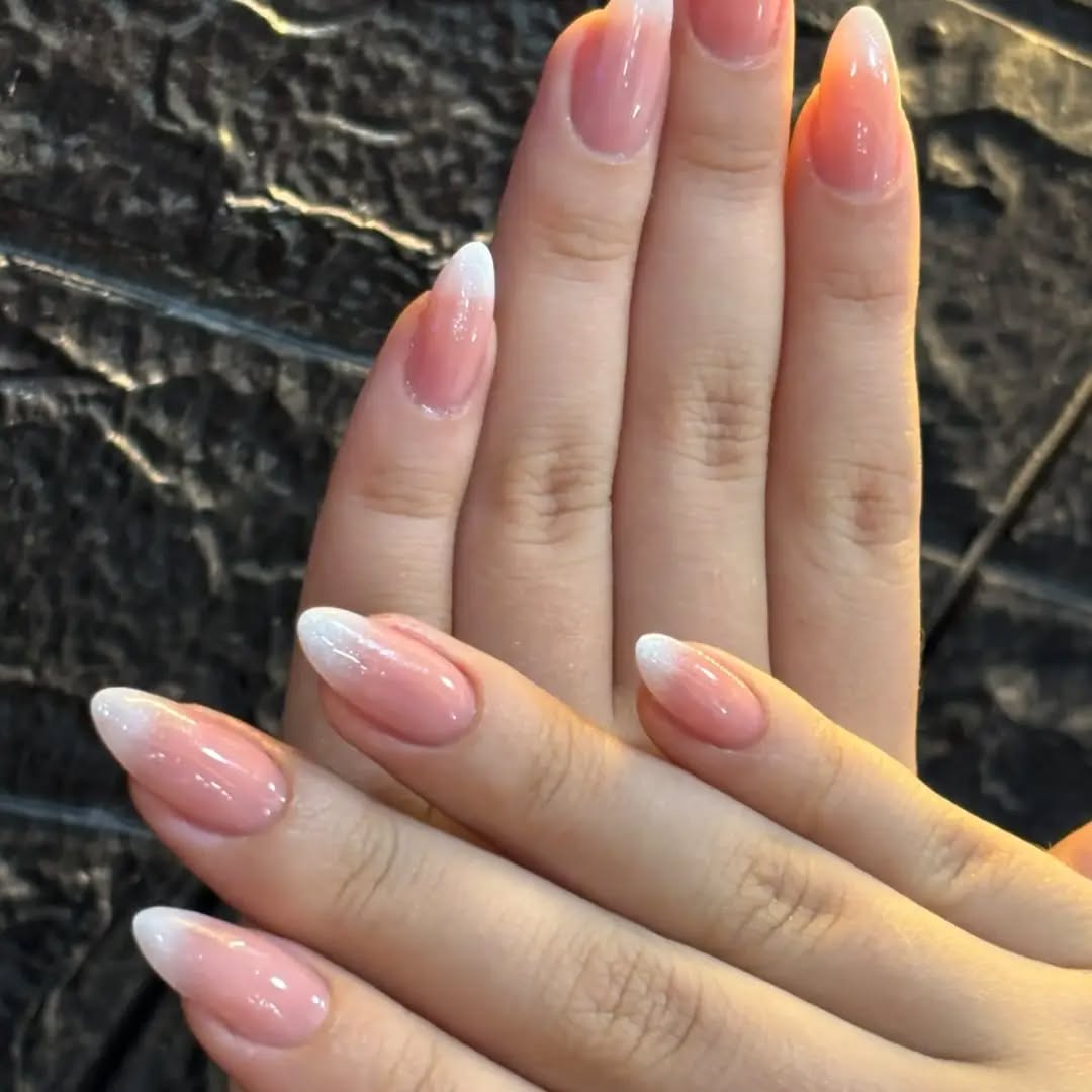 Manos con uñas almendradas largas en degradado rosado a blanco