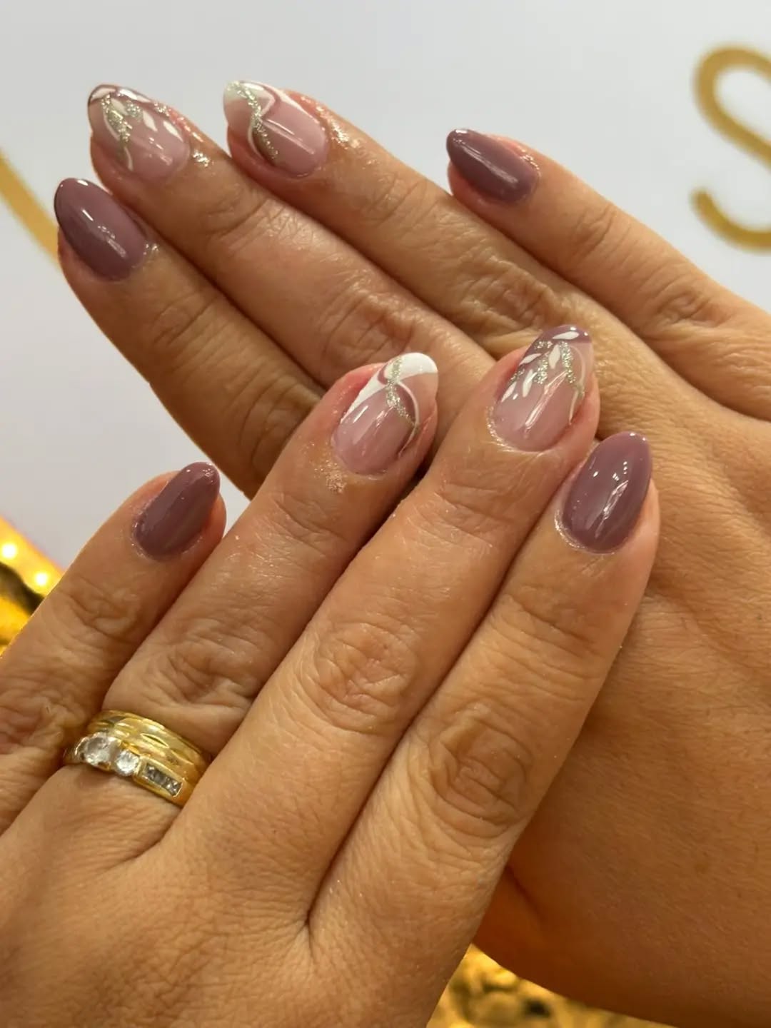 Manos con uñas almendradas en tono malva y diseño con brillo plateado